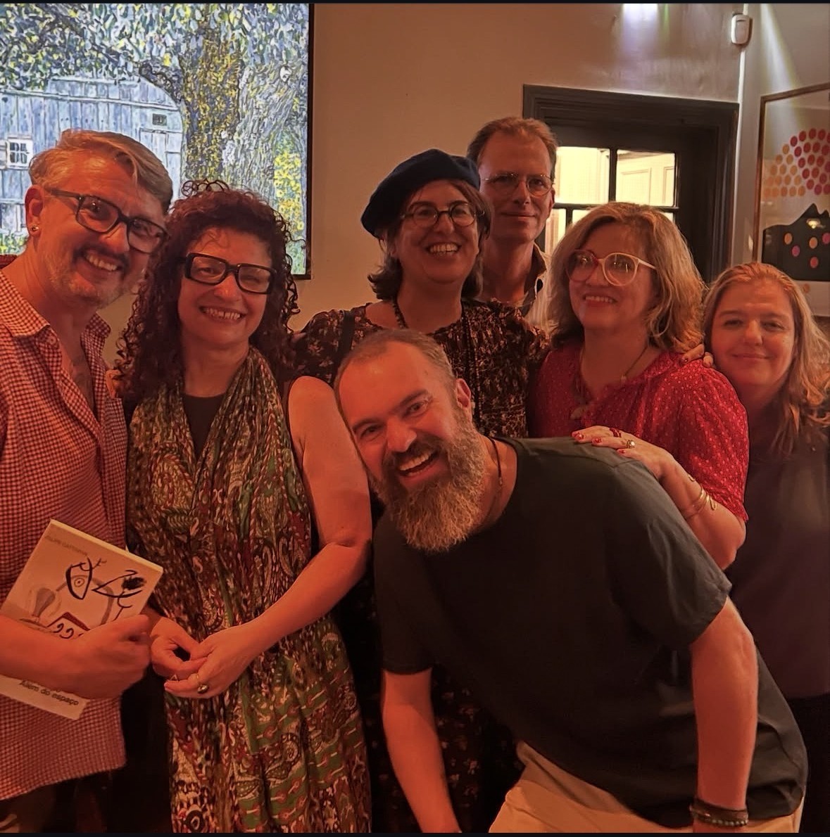 Group portrait of writers and guests, one holding a book, at the end of the evening.