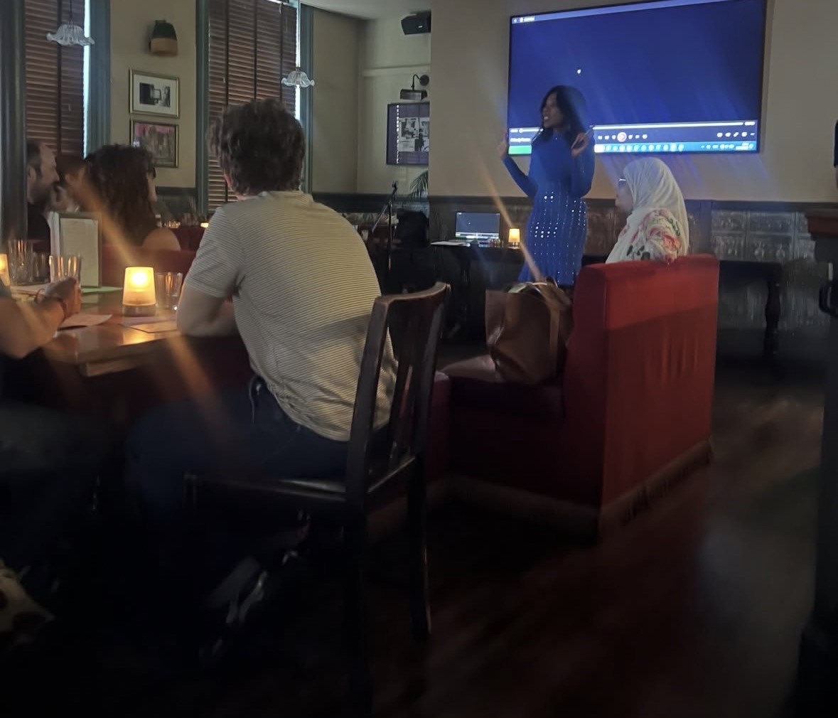 A reading in progress by candlelight, with the audience seated at tables on Casa do Sarau's first night.