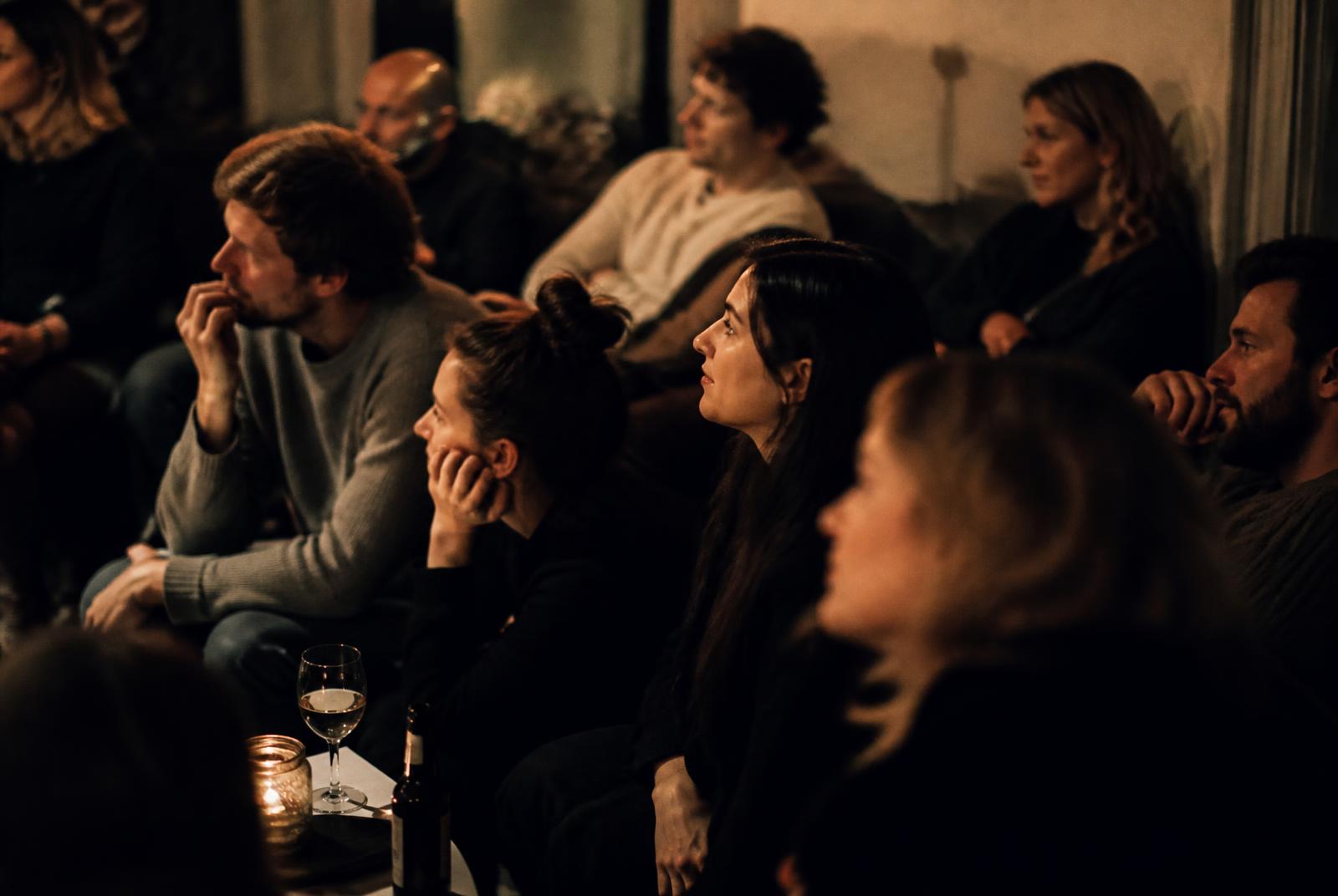 A small seated audience listening intently